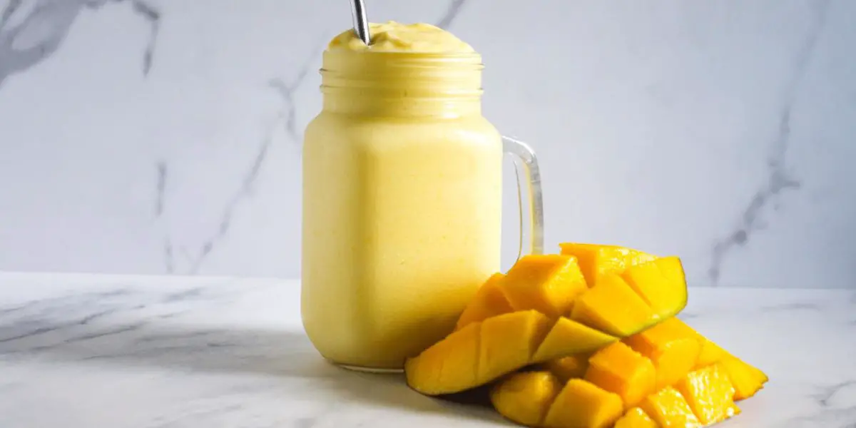 An image capturing the vibrant hues of a freshly blended Easy Mango Smoothie, showcasing its smooth texture and inviting tropical appeal. 