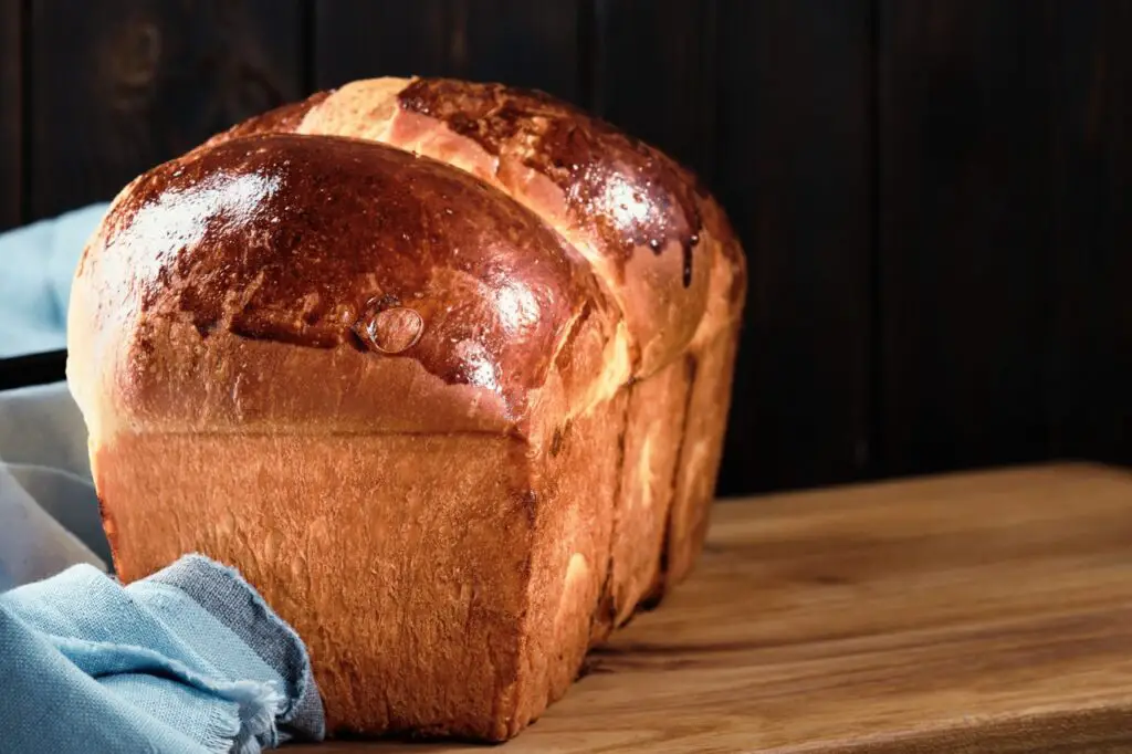 A tempting image showcasing a slice of brioche and a slice of sourdough bread side by side, highlighting their distinct textures and appearances.