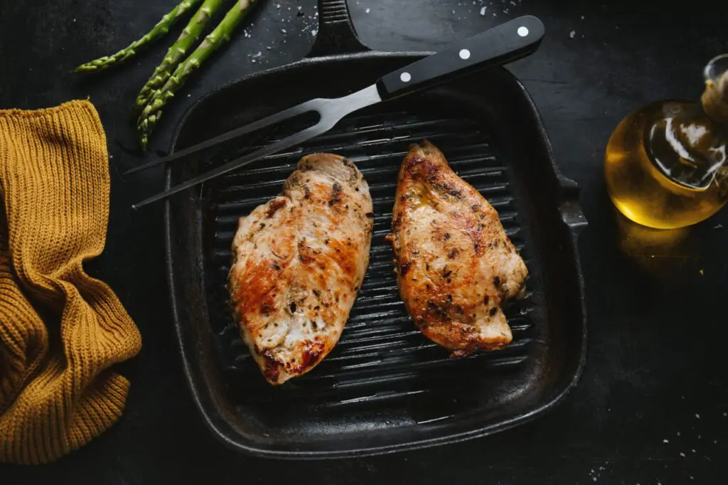 A sizzling Blackstone griddle cooking juicy chicken breasts with grill marks.