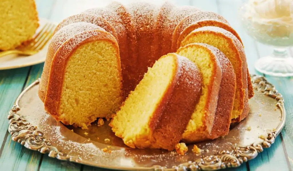An inviting image showcasing Grandma's Sour Cream Pound Cake, beautifully golden and adorned with a dusting of powdered sugar. The moist crumb and nostalgic aroma promise a delightful taste of tradition and love.