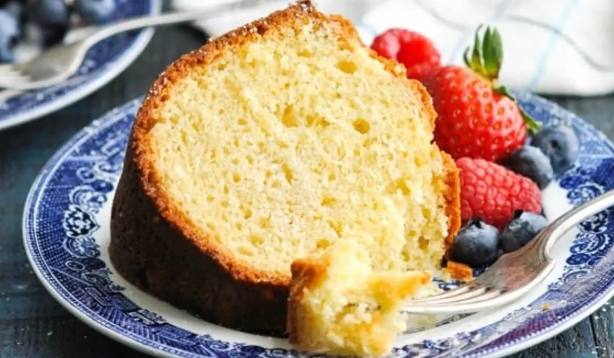 An inviting image showcasing Grandma's Sour Cream Pound Cake, beautifully golden and adorned with a dusting of powdered sugar. The moist crumb and nostalgic aroma promise a delightful taste of tradition and love.