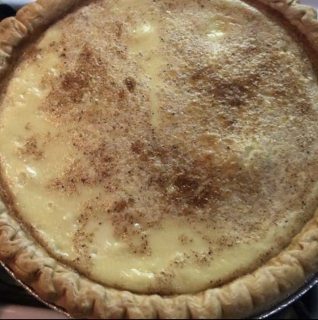 Golden-brown Old School Egg Custard Pie with a creamy, vanilla-infused filling, showcasing homemade goodness and timeless simplicity