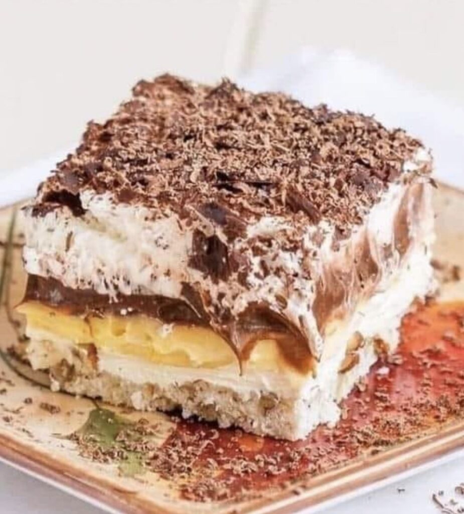 A tantalizing image showcasing the layers of "Sex in a Pan" Cake Delight—a golden graham cracker crust, velvety cream cheese, silky pudding, and a glossy chocolate ganache topping. Each layer promises a symphony of flavors in this irresistible dessert.