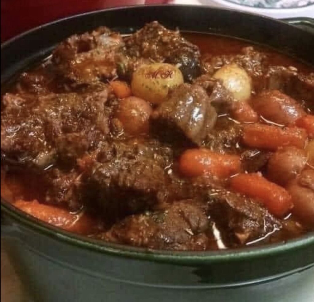 A tempting image capturing a steaming bowl of the Best Ever Beef Stew, showcasing succulent chunks of beef, colorful vegetables, and fragrant herbs in a rich broth. The inviting warmth and homely charm of this classic comfort dish are beautifully presented.