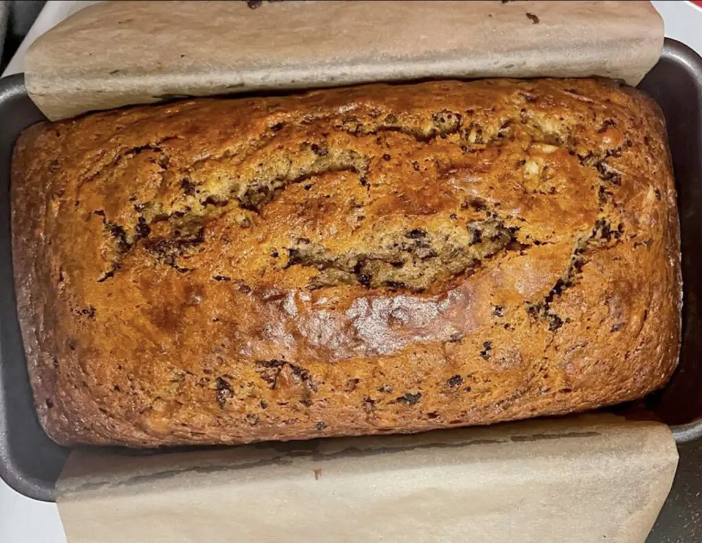 A delightful image showcasing a freshly baked loaf of Banana Bread, its golden-brown crust and moist interior inviting you to enjoy a slice. Optionally adorned with nuts, chocolate chips, or a dusting of cinnamon.