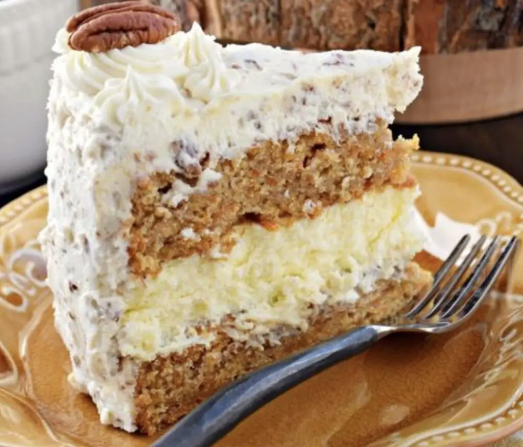 An enticing image featuring a slice of Carrot Cake Cheesecake, showcasing the layers of velvety cheesecake and spiced carrot cake. Optionally topped with a luscious cream cheese frosting, it's a visual and gastronomic delight.