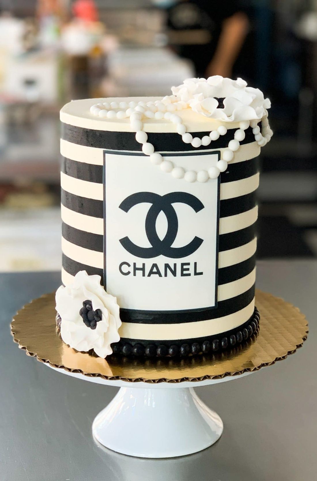 A visually stunning Chanel cake, adorned with quilted patterns and the iconic double-C logo, showcasing the epitome of culinary elegance and high fashion.