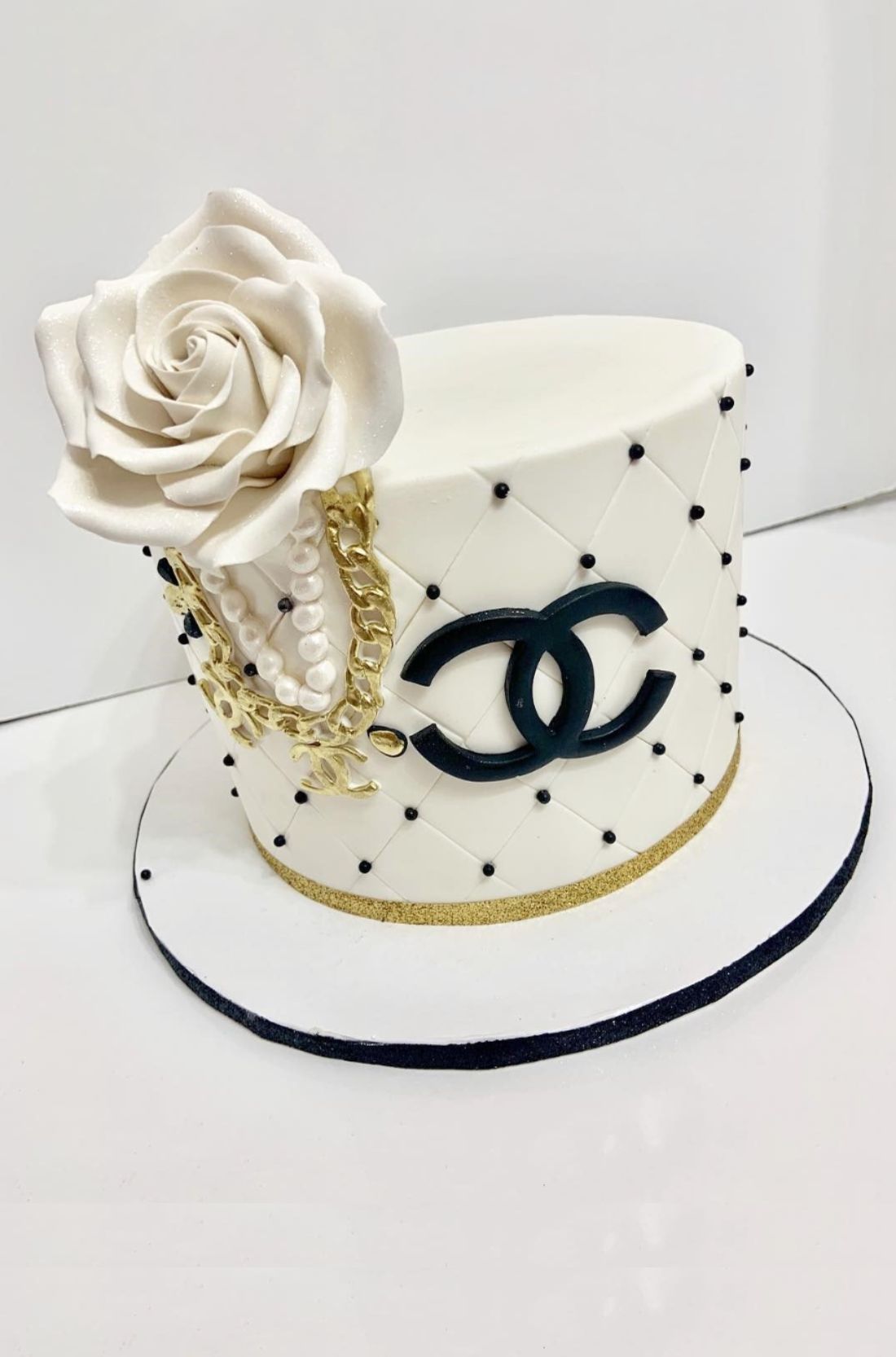A visually stunning Chanel cake, adorned with quilted patterns and the iconic double-C logo, showcasing the epitome of culinary elegance and high fashion.